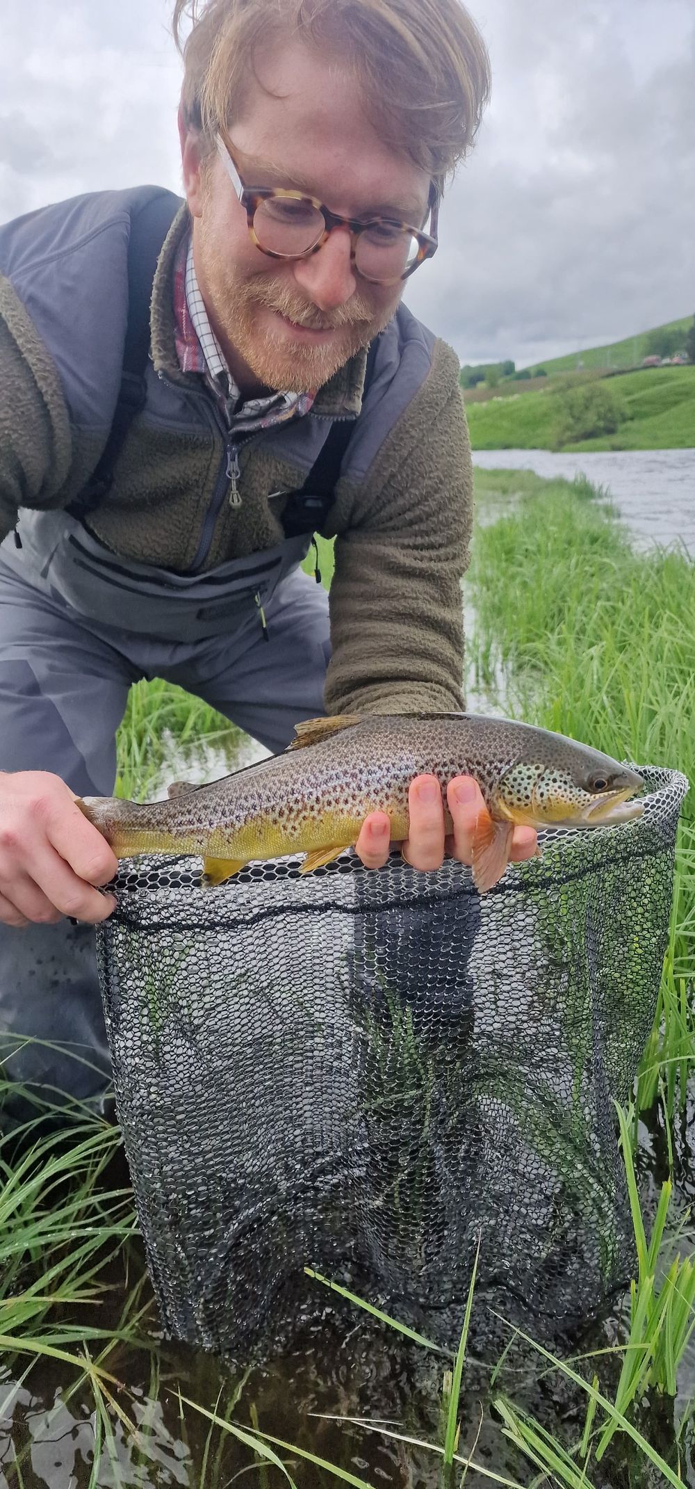 Client with a beautiful wild brown trout in a landing net