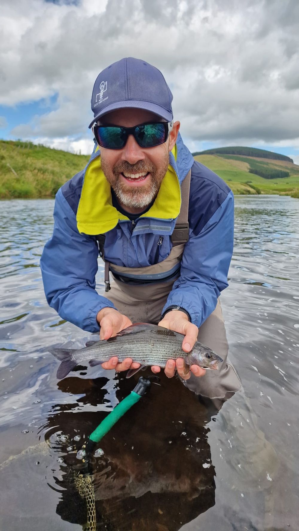 Client with a grayling, Scottish river and hills