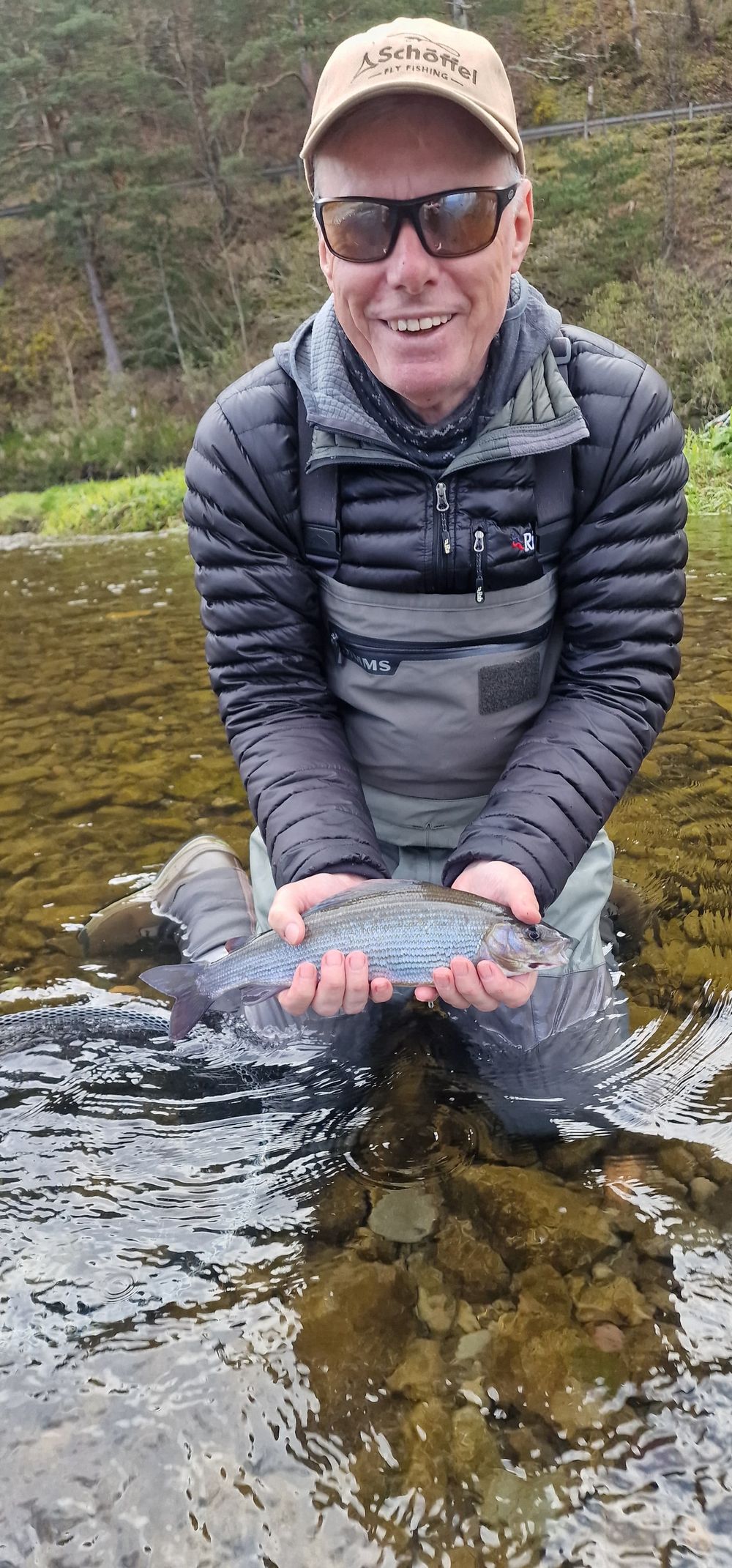 Client with a grayling on an autumn Scottish river