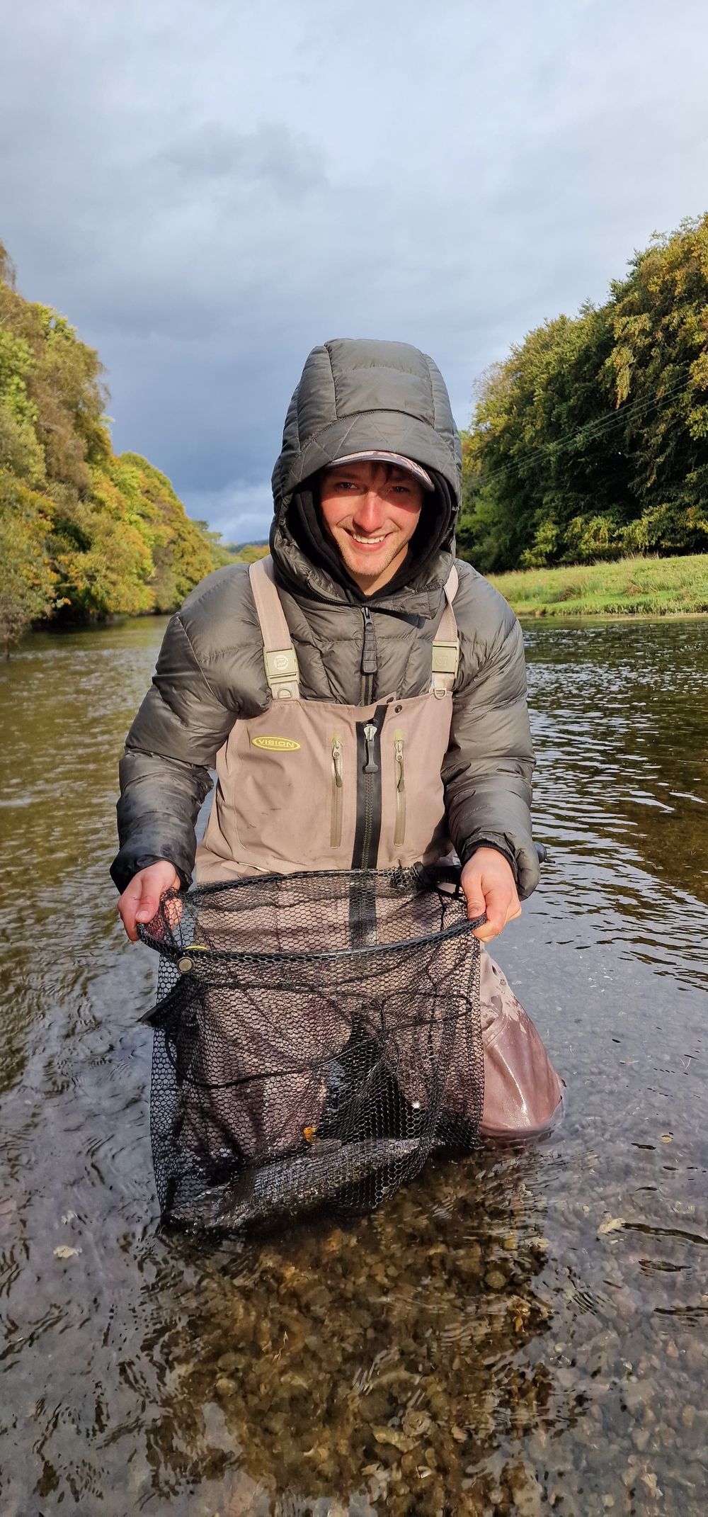Client with a full landing net on an autumn river